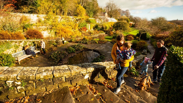 A family exploring the garden in autumn at Wallington, Northumberland